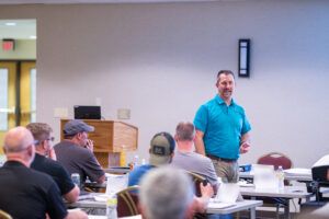 Instructor presenting to a group of attentive TAB students.